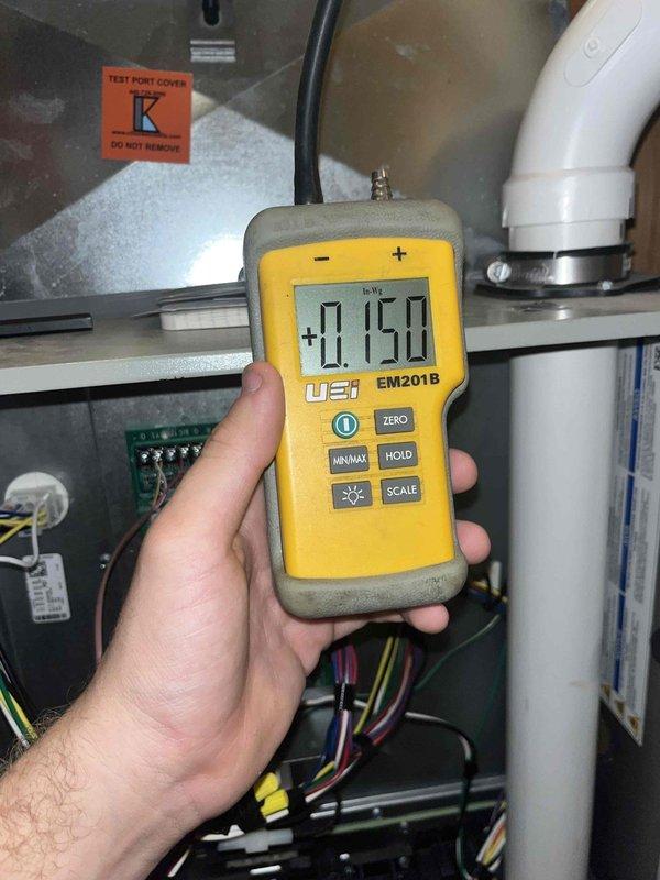 Completed heating maintenance club visit and performed system inspection. Examined and documented air filter condition, showing moderate dust accumulation requiring attention. Measured gas pressure at test port using calibrated digital manometer, recording -0.150 InWg to verify proper system operation and combustion air pressure levels within manufacturer specifications.