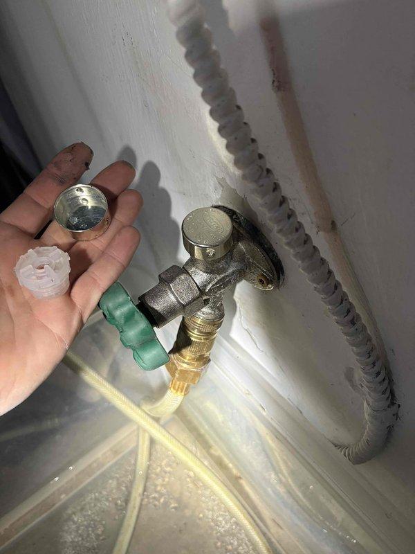 Completed return visit for pipe repair service previously sold. Accessed interior wall cavity through existing service panel to inspect and repair black PVC drainage system with Y-configuration. Removed and replaced defective plumbing components including threaded metallic cap, white plastic washer, and green plastic adapter fitting. Serviced T-shaped metal valve assembly with multiple connection points in utility area, ensuring proper installation of compression fittings and secure connections to flexible corrugated supply line. All replaced components tested for proper function and verified no leaks present upon completion.
