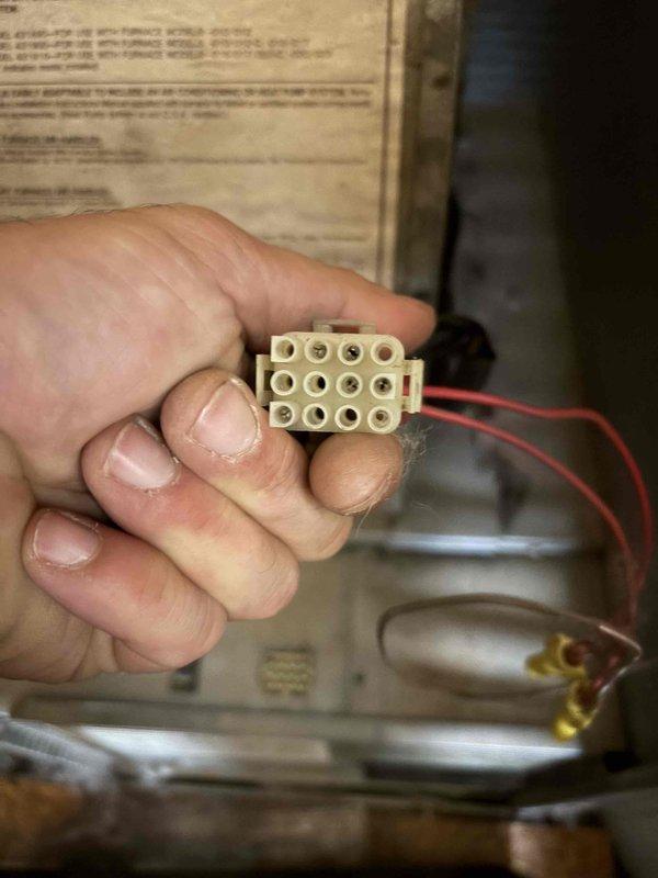 Responded to no-heat call on original 1988 furnace unit installed in mobile home utility closet. Upon arrival, diagnosed failed blower motor on 38-year-old system. Removed defective motor and associated electrical connector terminal block from furnace housing. Due to the age of the equipment and unavailability of compatible replacement parts for this vintage unit, advised customer of system's condition and discussed replacement options. Documented equipment condition and failed components with photographs for reference.