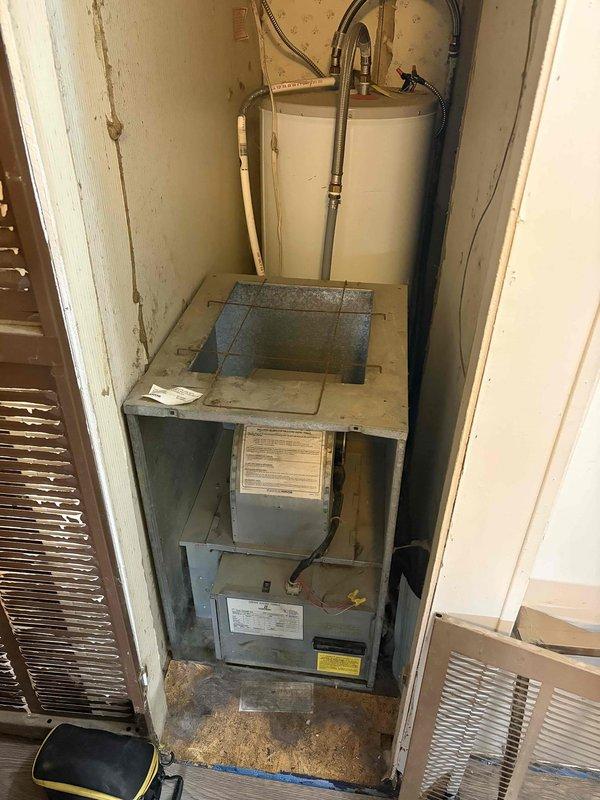 Responded to no-heat call on original 1988 furnace unit installed in mobile home utility closet. Upon arrival, diagnosed failed blower motor on 38-year-old system. Removed defective motor and associated electrical connector terminal block from furnace housing. Due to the age of the equipment and unavailability of compatible replacement parts for this vintage unit, advised customer of system's condition and discussed replacement options. Documented equipment condition and failed components with photographs for reference.