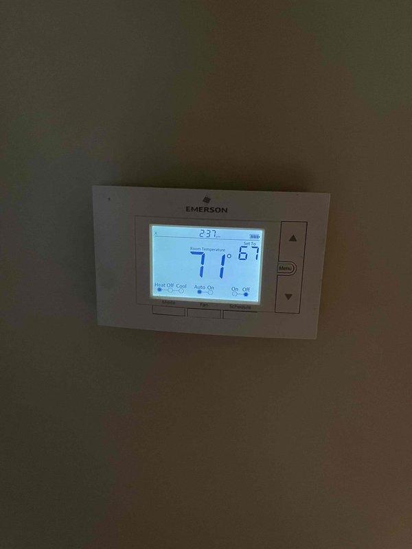 Completed scheduled heating maintenance member visit and performed comprehensive system inspection. Verified thermostat operation showing 71°F current temperature with system in auto mode, and conducted electrical diagnostics using digital multimeter which confirmed proper voltage readings at 47.7 on the heating system components.