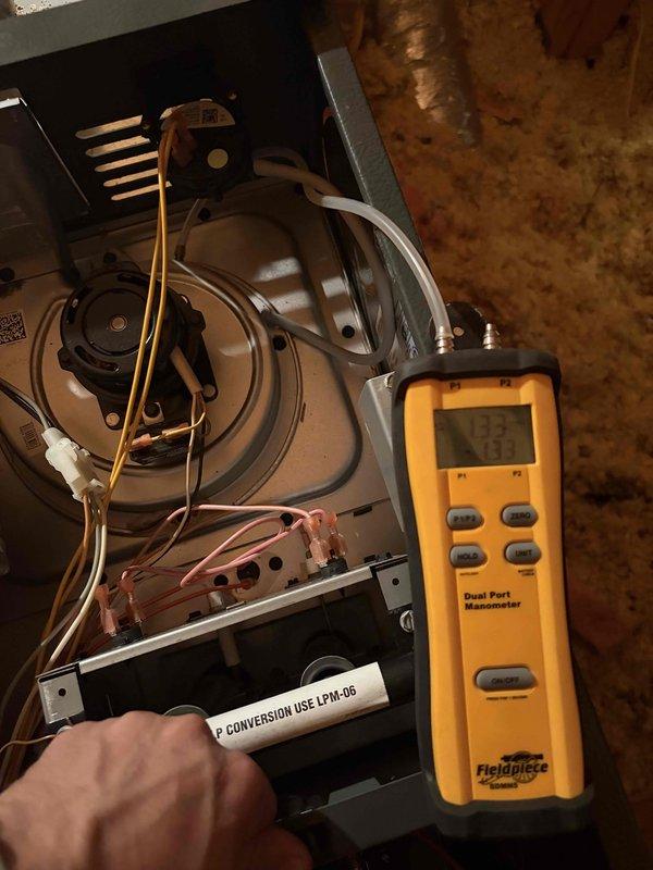 Responded to complaint of furnace failing to reach the 65°F setpoint on an approximately 11-year-old unit. Inspected the inducer motor and pressure switch circuit, verifying draft pressure with a digital manometer and measuring amp draw on the control wiring with a clamp meter. Confirmed the unit is equipped with an LP conversion kit and tested the system for proper operation; the furnace is now heating and cycling normally.