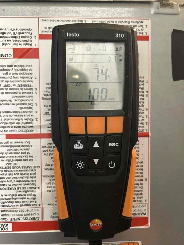 Performed a tune-up on the furnace in response to a reported rattling noise during operation, inspecting the cabinet interior, wiring connections, and vent/flue tubing for loose or worn components. Conducted a combustion analysis with a Testo 310 analyzer, which recorded 7.4% O2 and 100 ppm CO, indicating CO levels at the upper limit of acceptable range and warranting further burner and heat exchanger evaluation. Interior of the cabinet showed dust accumulation and minor surface corrosion near the seam, which should be monitored.