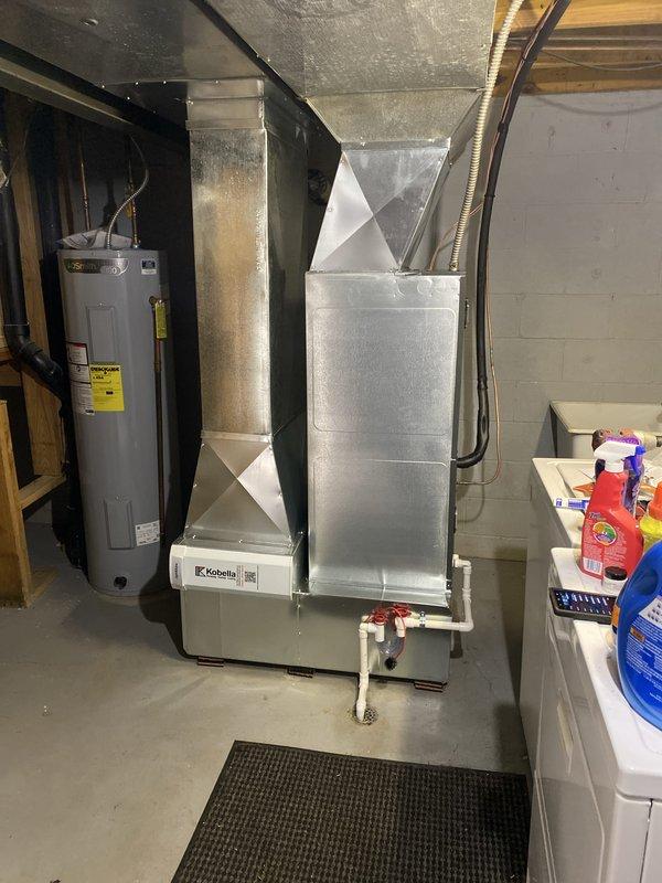 Installed an Amana AMVT variable-speed air handler (2-ton, 15 SEER heat pump system) in the basement utility area, with galvanized supply plenum and transitions connected to the existing ductwork and PVC condensate drain piping with isolation valves routed to the floor drain. Verified static pressure with a dual-port manometer (0.26 IWC supply / -0.30 IWC return) to confirm airflow is within acceptable operating range.