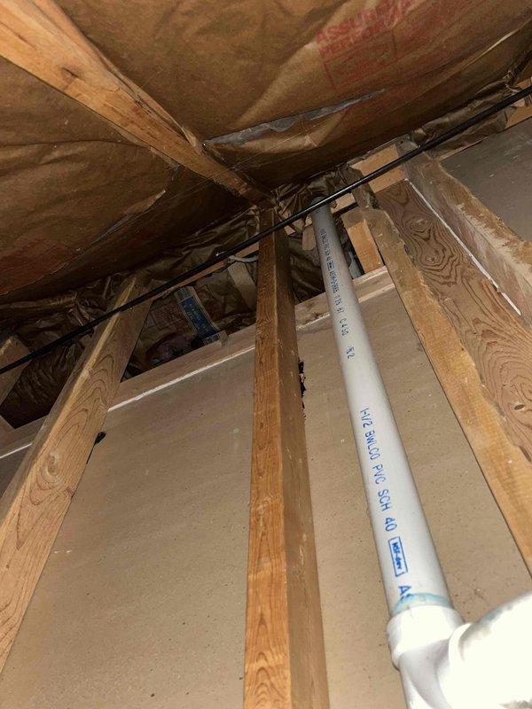 Returned to the site to evaluate the reported noise from the Navien boiler. Inspected the accessible framing cavities and surrounding piping, including the 1-1/2" DWV PVC drain/vent runs, fittings, and nearby wiring, and checked the surrounding insulation for loose or contacting components that could transmit sound. Documented the condition of the piping and support areas with photos to assist in diagnosing the source of the noise.