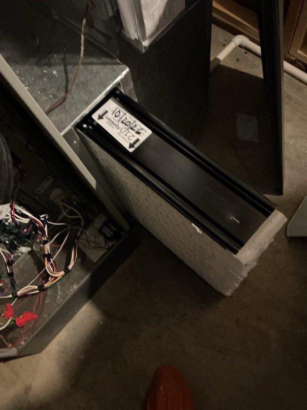 Performed a seasonal heating maintenance visit on a Trane gas furnace, replacing the pleated return air filter and labeling it with the service date for future reference. Inspected the furnace cabinet, wiring harness, PVC vent and condensate piping, and adjacent Aprilaire unit, finding no signs of frost, rust, or damage, and left the system operating normally with the service tag attached.