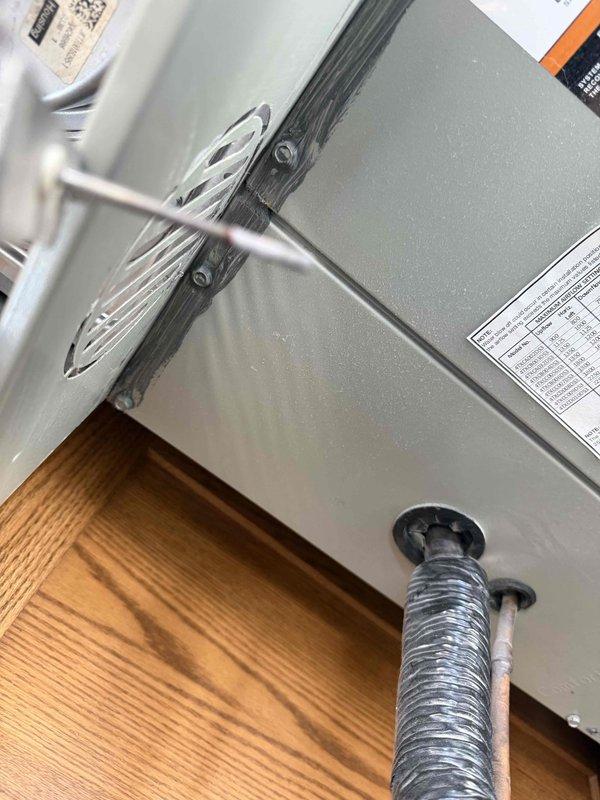 Responded to a complaint of a high-pitched noise at furnace startup lasting a short duration. Inspected the air handler cabinet and began diagnostics with the draft inducer motor, measuring motor amperage with a true RMS clamp meter (reading 3.92 A) to evaluate motor and bearing condition. Verified cabinet seams and sealant, as well as refrigerant line and pipe penetrations at the cabinet base, to rule out air leakage or vibration as the source of the noise.