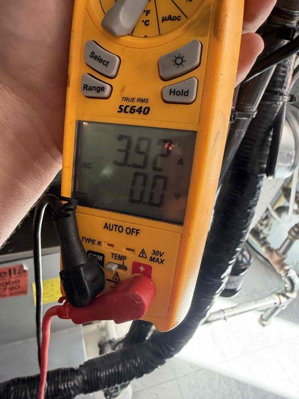 Responded to a complaint of a high-pitched noise at furnace startup lasting a short duration. Inspected the air handler cabinet and began diagnostics with the draft inducer motor, measuring motor amperage with a true RMS clamp meter (reading 3.92 A) to evaluate motor and bearing condition. Verified cabinet seams and sealant, as well as refrigerant line and pipe penetrations at the cabinet base, to rule out air leakage or vibration as the source of the noise.