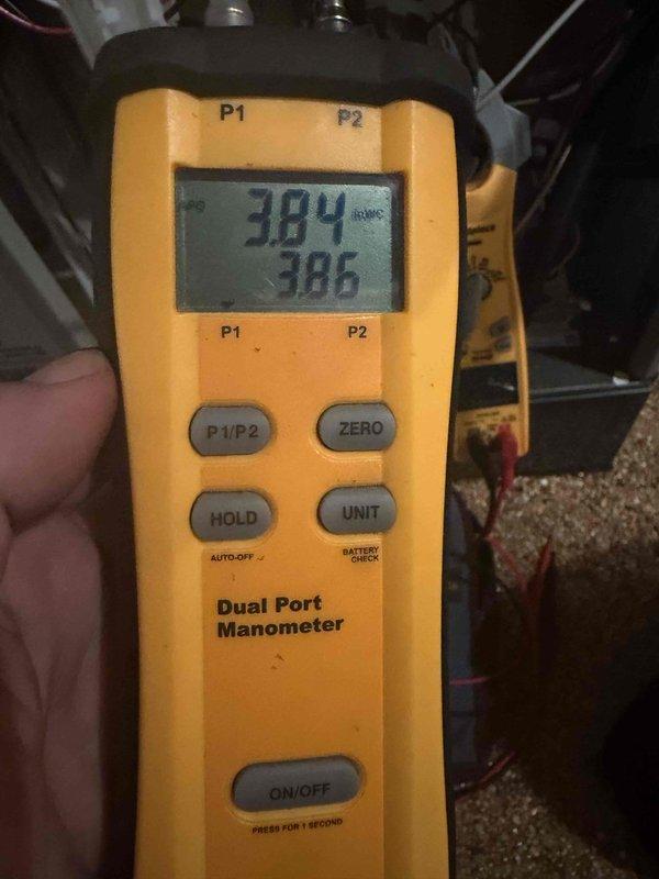 Performed seasonal heating maintenance and measured system differential pressure with a dual port manometer to verify proper airflow and static pressure. Inspected the AprilAire humidifier water panel (evaporator pad) and found heavy mineral buildup and discoloration, indicating it was due for replacement.