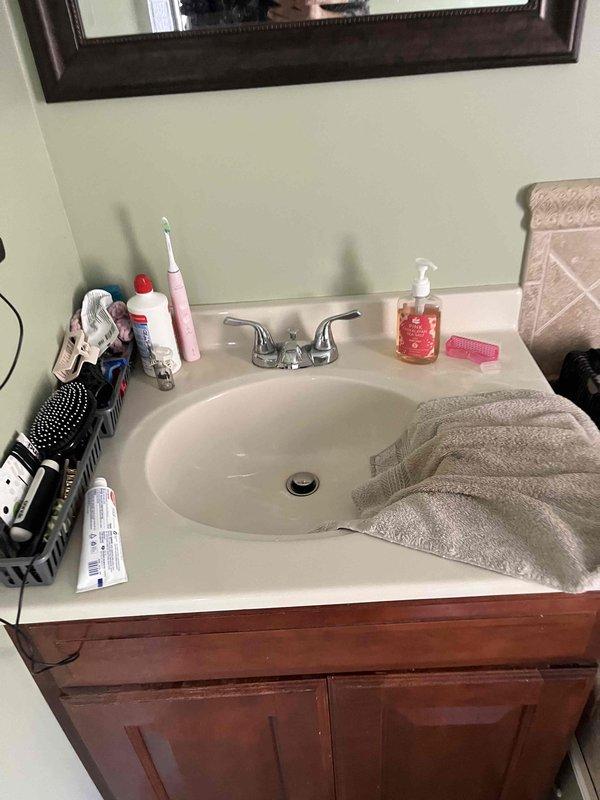 Inspected the reported non-functioning garbage disposal and evaluated the associated drain system for venting issues. Examination of the under-sink drain assembly, including the tailpiece, P-trap, slip-nut connections, and flexible trap arm to the wall, showed no leaks, corrosion, or visible damage. No bathroom sink components or photographed areas showed evidence of a disposal unit or a vent-related deficiency, so further diagnosis of the disposal and its venting is recommended at the kitchen fixture.