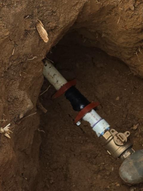 We responded to our customers County Club after they reported difficulty accessing and operating the existing curb stop in front of the clubhouse, near the stairs to the right of the main entrance. The previous curb stop had become buried by landscaping and soil, making it hard to locate and use during maintenance or in an emergency. To correct this issue, we replaced the two inch curb stop to ensure reliable shut off control for the building. Due to nearby irrigation and electrical lines, the area had to be hand dug approximately five feet deep to access the valve. Once the new curb stop was installed, we added an adjustable valve box cover to improve long term accessibility. The valve box was set slightly above the surrounding landscaping to prevent dirt from falling in and covering the the curb stop again. This upgrade ensures the valve remains accessible and functional for future service needs or emergencies.   