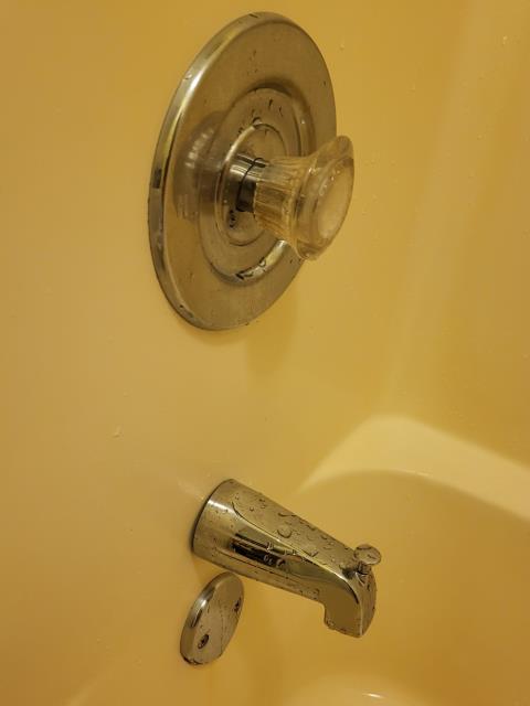 We responded to our customer after they noticed water leaking onto the main floor when the upstairs bathtub was being used. Once on site, we tested the tub and drain system and did not find any active leaks coming from the tub shoe, overflow, or plumbing connections. To further investigate this issue, we ran the tub and splashed water around the tub spout and trim area. During testing, we observed water getting behind the trim, which was allowing moisture to travel into the wall and leak down to the level below. This type of leak is often caused by failed or missing sealant around the tub trim. To resolve this issue, we sealed the trim with clear caulking to create a water tight barrier. After sealing, we retested the area to confirm water was no longer getting behind the trim. 