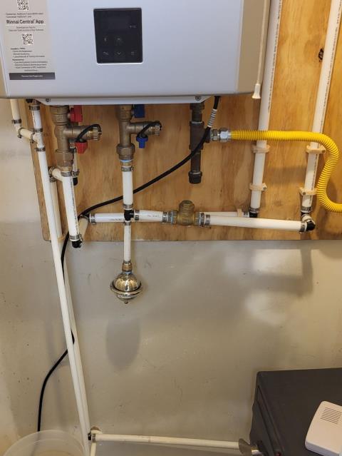 We responded to our customer in Marietta, GA after they reported their tankless water heater condensate line had frozen outside, which can prevent the unit from draining properly and cause shutdown issues. On site, we inspected the drain and confirmed the existing 1/2 inch line was too small and had frozen, restricting condensation flow. To prevent future freezing and improve drainage, we removed the existing 1/2 inch PEX line, drilled a larger opening, and installed new 3/4 inch PVC piping for the condensate line. After completing the installation, we turned the hot water back on and tested the tankless system for proper operation and leak-free connections. 