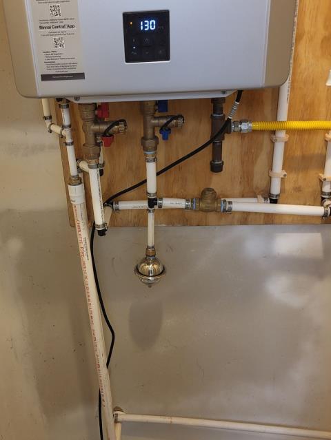 We responded to our customer in Marietta, GA after they reported their tankless water heater condensate line had frozen outside, which can prevent the unit from draining properly and cause shutdown issues. On site, we inspected the drain and confirmed the existing 1/2 inch line was too small and had frozen, restricting condensation flow. To prevent future freezing and improve drainage, we removed the existing 1/2 inch PEX line, drilled a larger opening, and installed new 3/4 inch PVC piping for the condensate line. After completing the installation, we turned the hot water back on and tested the tankless system for proper operation and leak-free connections. 
