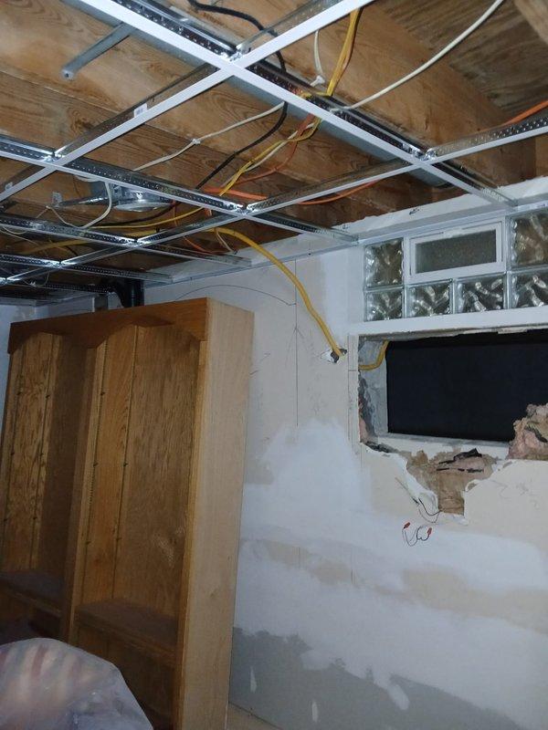 Successfully relocated laundry drain from basement floor to elevated position in nearby wall stack, eliminating previous suds issue. Completed installation of customer-supplied stainless double bowl sink and kitchen faucet. Two-person crew completed all work as specified.