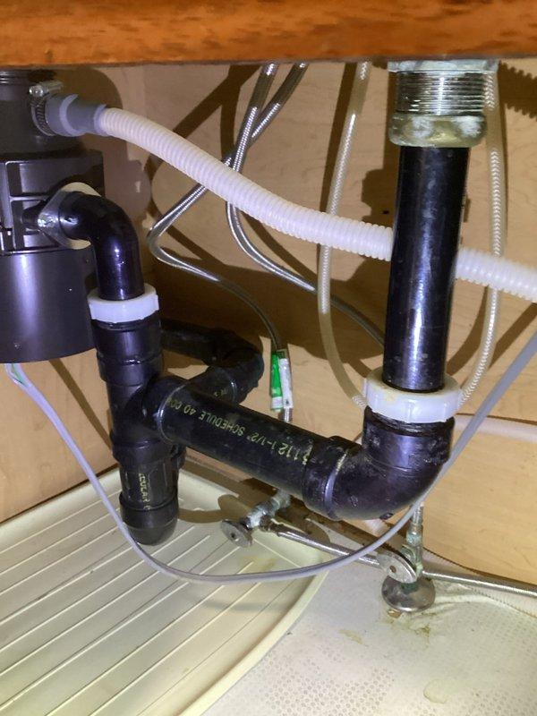 Responded to service call for slow draining disposal and suspected leak on T-valve. Inspection revealed no active leaks in the P-trap assembly or compression fittings. Performed thorough cleaning of the disposal and drain line to restore proper drainage function. All connections and supply lines verified secure and operational.