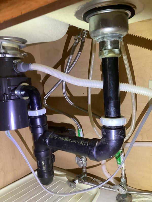 Responded to service call for slow draining disposal and suspected leak on T-valve. Inspection revealed no active leaks in the P-trap assembly or compression fittings. Performed thorough cleaning of the disposal and drain line to restore proper drainage function. All connections and supply lines verified secure and operational.