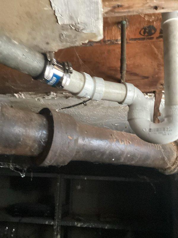Responded to service call regarding broken tub drain. Inspected existing plumbing system and found deteriorated drain assembly. Removed corroded metal drain components and replaced with new PVC P-trap configuration, properly secured with metal clamps to wooden joists. Connected new assembly to existing drain line, ensuring proper slope for drainage.