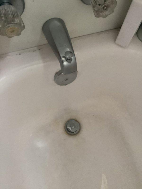 Responded to service call regarding broken tub drain. Inspected existing plumbing system and found deteriorated drain assembly. Removed corroded metal drain components and replaced with new PVC P-trap configuration, properly secured with metal clamps to wooden joists. Connected new assembly to existing drain line, ensuring proper slope for drainage.