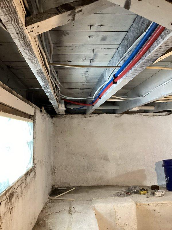 Completed replacement of damaged CPVC piping system with new color-coded PEX water supply lines throughout the basement. Installed proper P-trap drainage assembly with corresponding hot and water supply lines terminating at brass shutoff valves for washing machine hookup. All new PEX lines were securely fastened to ceiling joists with appropriate hangers and tested for leaks.