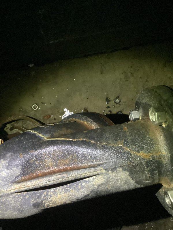 Responded to service call for main water line leak occurring inside property before the meter. Upon inspection, discovered severely corroded metal pipe connection with visible water pooling around the mechanical joint. Replaced deteriorated pipe section and flanged connection, securing with new bolts to ensure watertight seal. Confirmed proper operation with customer before departure.