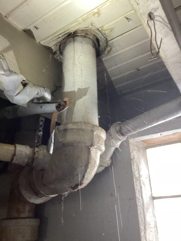 Responded to a water leak call at a 35-year-old residence involving a bathtub drain. Upon inspection, accessed plumbing through a removed wall tile and identified aging P-trap assembly in the utility area showing signs of water damage and deterioration at ceiling connection. Replaced compromised drain components, sealed connections properly, and verified system integrity with leak test before completing the repair.