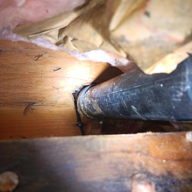 Responded to a commercial water leak in a garage ceiling beneath kitchen sink area. Upon inspection, discovered deteriorated drywall, wet insulation, and water damage in the ceiling cavity. Located leak source at drain pipe junction where moisture was accumulating on pipe surfaces passing through wooden structural members, and completed necessary repairs to resolve the issue.