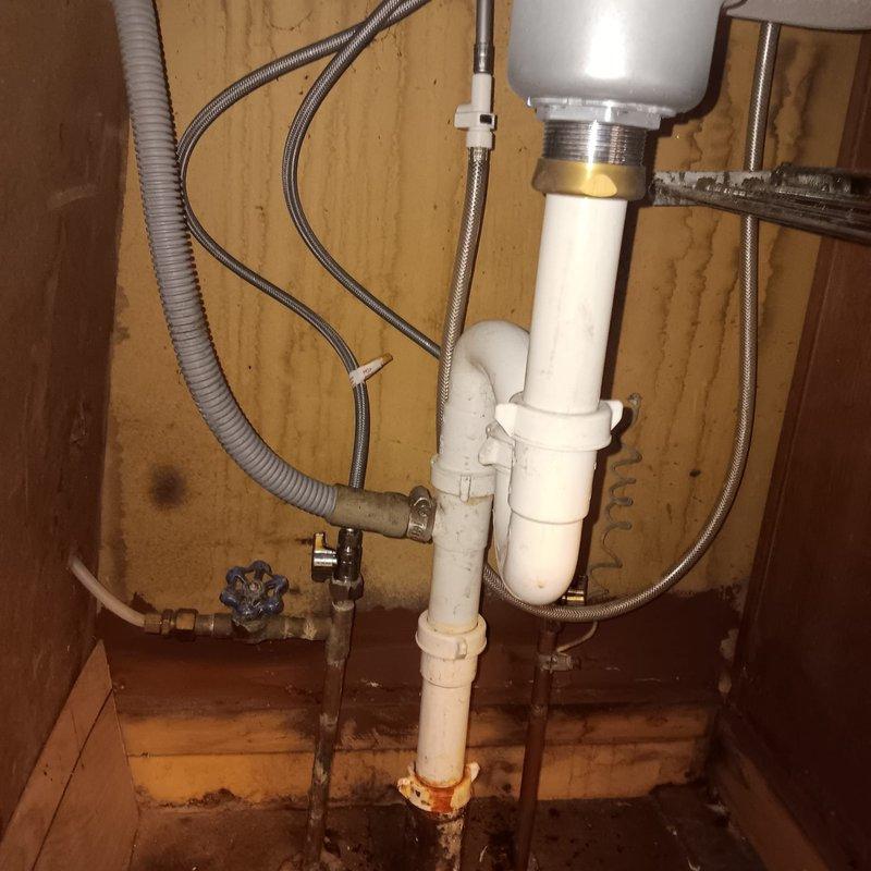 Responded to a service call for a clogged sink at a residential property built in 1951. Upon inspection, found significant blockage in the P-trap system under the sink causing drainage failure. Successfully cleared the obstruction, cleaned the affected PVC drain components, and verified proper water flow restoration through the plumbing system.