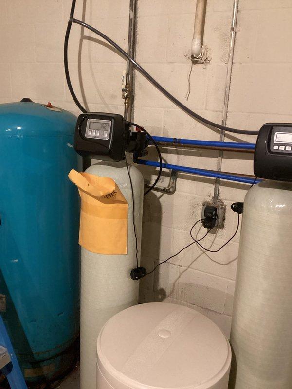Conducted assessment for conversion from well water to municipal supply. Documented existing well system requiring capping and current water treatment setup consisting of pressure tank, dual filtration units with control heads, and brine tank. Provided customer with estimate for well decommissioning and installation of new city water line connection.