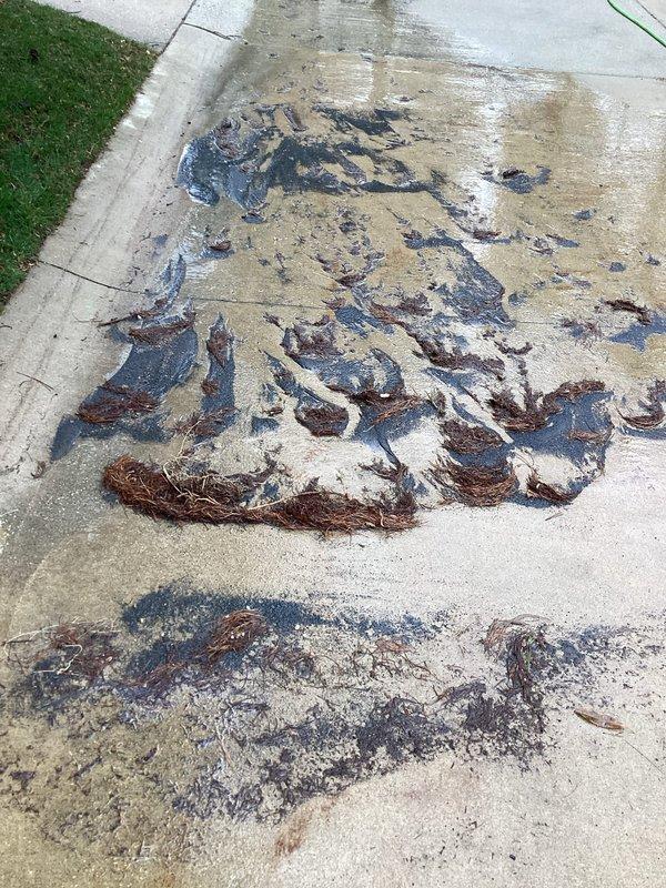 Responded to service call for clogged exterior downspout. Cleared accumulated organic debris (leaves and twigs) from the downspout system and removed blockage causing water backup. Noted oil staining on adjacent concrete surface that appears unrelated to the downspout issue.
