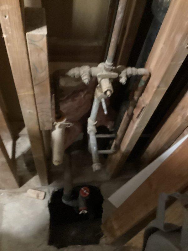 Installed new shut-off valves in bathroom, connecting to existing plumbing infrastructure within wall cavity. Accessed and serviced complex junction of PVC and metal pipes, ensuring proper connection of water supply lines to fixture via braided supply hose. Completed valve installation on hexagonal tile flooring with secure mounting.