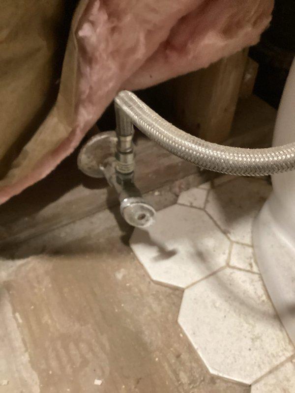 Installed new shut-off valves in bathroom, connecting to existing plumbing infrastructure within wall cavity. Accessed and serviced complex junction of PVC and metal pipes, ensuring proper connection of water supply lines to fixture via braided supply hose. Completed valve installation on hexagonal tile flooring with secure mounting.
