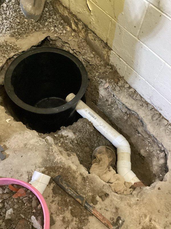 Completed basement shower removal with proper water line capping. Installed new sump pump system including concrete removal/replacement, footer drain redirection from floor drain to sump crock, floor drain riser repair, and installation of dedicated electrical outlet. Constructed 1½" PVC discharge line connecting to existing 4" PVC downspout drain with all debris removed from premises.
