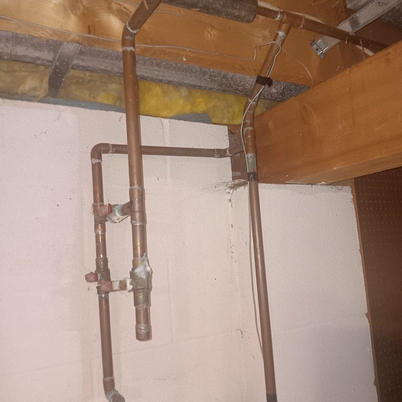 Responded to service call for shower drain leak and water heater inspection at 30-year-old residential property. Upon arrival, investigated shower drain system for reported leak and possible clog. Inspected exposed copper plumbing infrastructure in basement utility area, examining vertical and horizontal pipe runs, joints, and fittings for signs of leakage or deterioration. 

Conducted thorough examination of residential water heater unit, checking for active leaks versus condensation accumulation. Inspected all pipe connections at top of water heater, pressure relief valve, and surrounding floor area for moisture. Observed water staining on concrete basement floor and evaluated whether source was related to water heater operation or other plumbing components. Verified proper water heater operation and assessed condition of existing copper supply lines and fittings.

Documented existing plumbing infrastructure and mechanical equipment conditions through photographic evidence. Whole hom