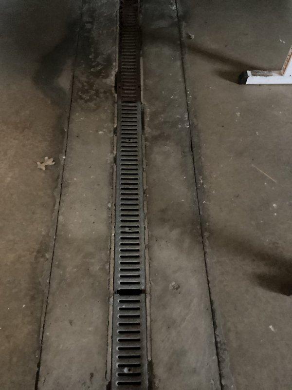 Provided comprehensive estimate for drain cleaning services at a commercial facility. Scope includes nine total drains requiring maintenance: three long trench drains, four short trench drains, and two floor drains located beneath a yellow grate in the utility area and within a cement mop basin. Photographic documentation captured existing conditions of drainage infrastructure including trench drain grates and utility room floor drain systems.
