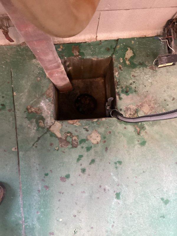 Provided estimate for comprehensive drain cleaning services at Station 2 commercial facility. Scope includes cleaning four total drains: three long trench drains and one floor drain located underneath the hose reel in front of the bays. Site inspection revealed deteriorated flooring conditions with weathered painted surfaces showing significant wear. Documented existing drainage infrastructure including metal trench grate systems with horizontal slat design and floor access point with copper piping. Photographic documentation completed to support estimate for cleaning services of all specified drainage components.