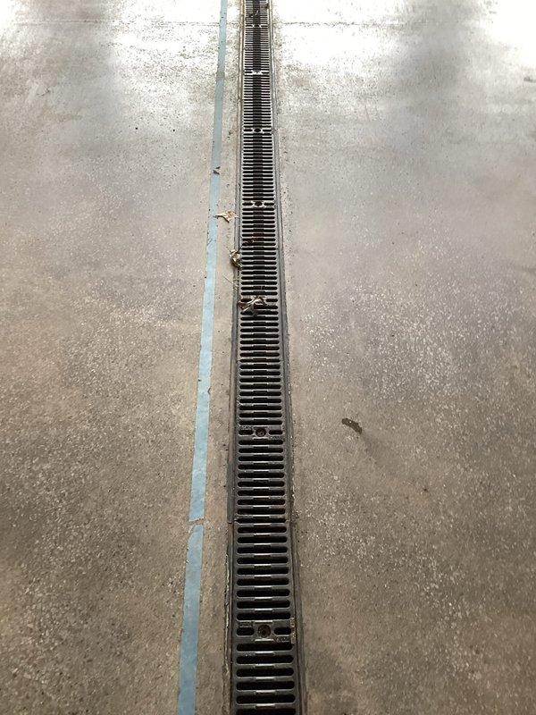 Provided comprehensive estimate for commercial sewer line cleaning services covering six long trench drains at Station 3. Assessment included inspection of linear floor drainage systems with metal grates installed in concrete flooring, evaluation of debris accumulation within drain openings, and determination of equipment requirements including specialized wheeled drain cleaning machinery positioned on-site for the proposed work.