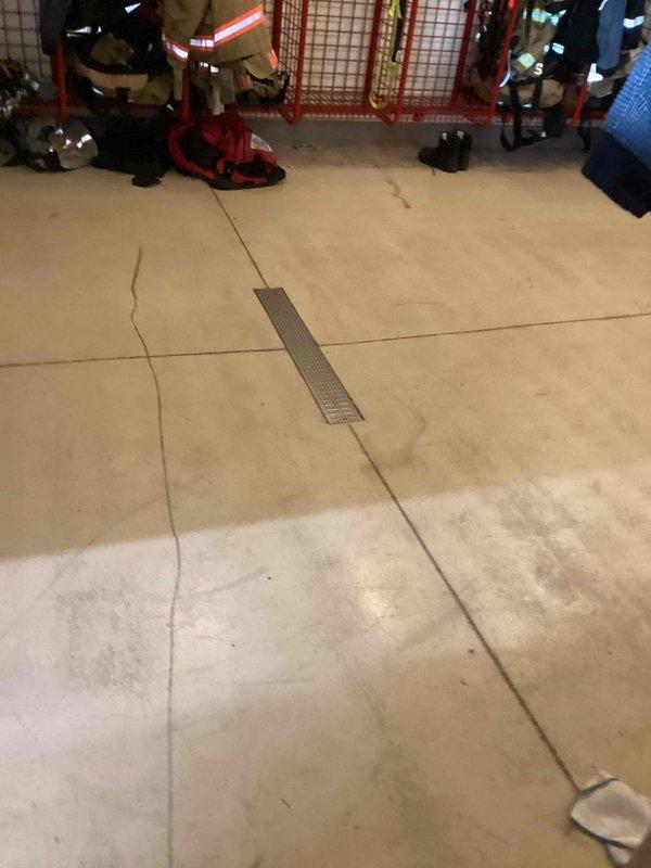 Provided comprehensive estimate for commercial drain cleaning services at fire station facility encompassing 11 total drains including 8 long trench drains, 3 floor drains located in gear room and walkway areas, and 2-4 interior catch basins. Conducted thorough site assessment and documented existing floor drain conditions in high-traffic areas showing standard wear patterns and drainage infrastructure requiring maintenance.