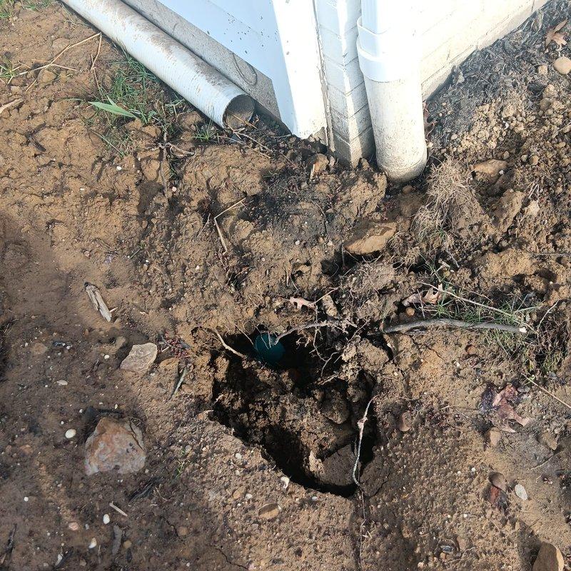 Responded to drainage valve disconnection issue resulting from previous pipe replacement work. Upon arrival, located disconnected drainage valve at ground level near foundation of older residential property. Excavated area revealed multiple PVC drainage lines with one valve assembly improperly terminated. Reconnected drainage valve to existing pipe system, ensuring proper alignment and secure fitting. Tested valve operation and drainage flow to confirm system functionality. Backfilled excavation area and applied straw mulch for erosion control and ground stabilization.