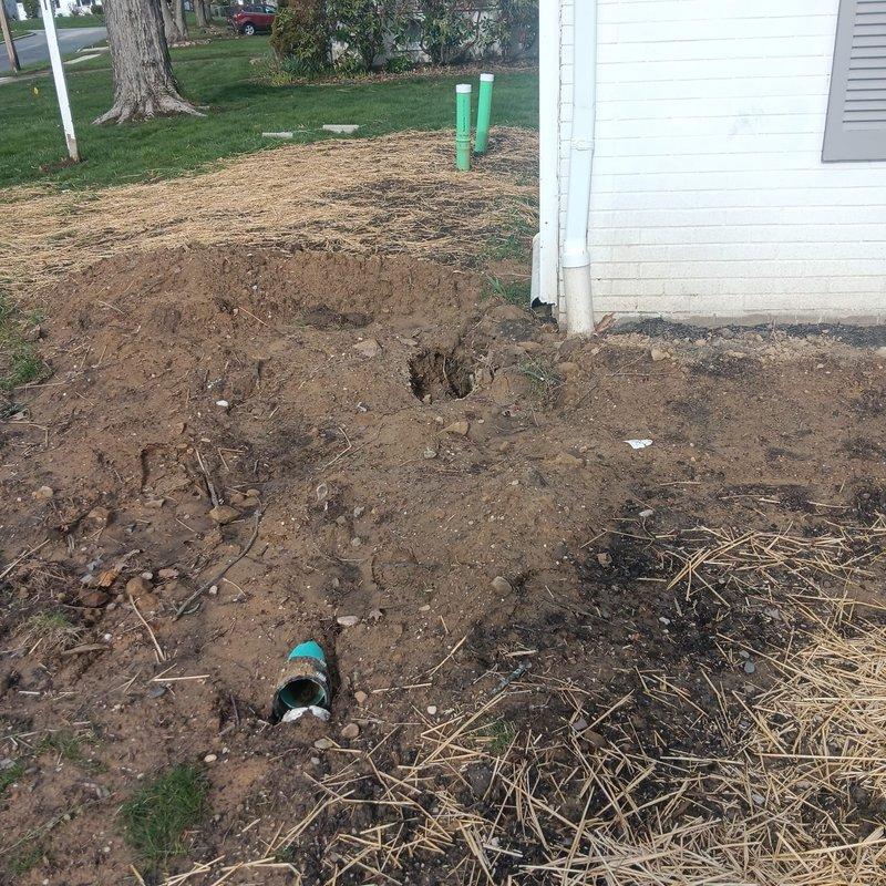 Responded to drainage valve disconnection issue resulting from previous pipe replacement work. Upon arrival, located disconnected drainage valve at ground level near foundation of older residential property. Excavated area revealed multiple PVC drainage lines with one valve assembly improperly terminated. Reconnected drainage valve to existing pipe system, ensuring proper alignment and secure fitting. Tested valve operation and drainage flow to confirm system functionality. Backfilled excavation area and applied straw mulch for erosion control and ground stabilization.