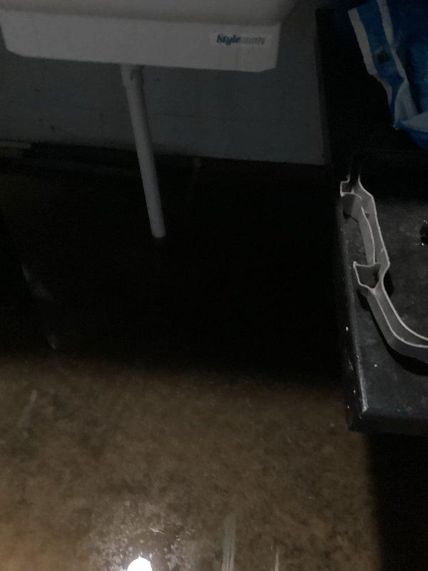 Responded to flooding issue affecting basement and garage areas. Upon inspection, observed water infiltration problems with existing trench drain system proving inadequate for current groundwater volume. Assessed interior basement utility area showing evidence of water accumulation on concrete floor surfaces. Evaluated exterior entrance area where significant foundation settlement and concrete paver cracking was creating direct water pathways toward building. Documented compromised drainage conditions including structural cracks in walkway allowing surface water penetration. Recommended enhanced drainage solutions to address insufficient capacity of current system and prevent continued water intrusion into below-grade spaces.