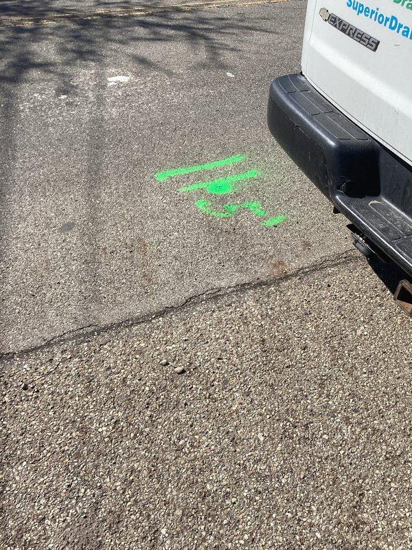 Responded to sewer line emergency during scheduled availability window. Upon arrival, performed visual inspection and diagnostic assessment of reported collapsed sewer line at street connection. Documented existing conditions with photographic evidence showing utility markings on pavement surface indicating underground infrastructure location and active water intrusion in basement area with standing water and floor deterioration. Confirmed sewer line failure requiring full replacement from structure to street connection. Provided professional assessment and documentation for complete sewer line replacement project.