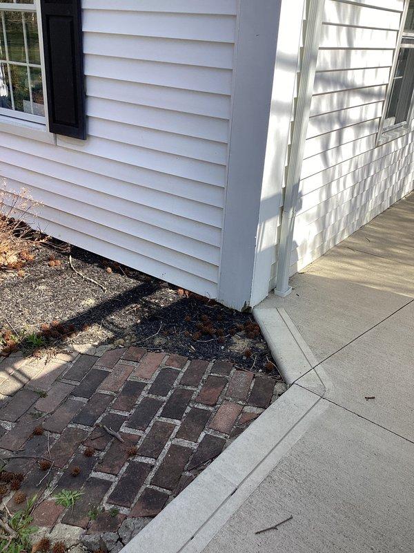 Responded to service call regarding water intrusion in garage. Assessed exterior drainage conditions and downspout configuration at property. Evaluated existing drainage patterns where foundation meets hardscape, noting water accumulation issues near building corner. Provided estimate for installation of additional downspout system with separate discharge point routing to street to improve water diversion and prevent garage flooding.