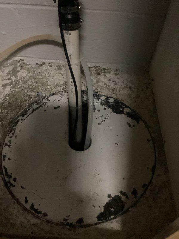 Responded to service call for sump pump evaluation. Upon inspection, found existing sump pump showing signs of burnout with significant deterioration of the basin crock. The sump basin exhibited extensive corrosion on the metal base plate, heavy biological growth including mold and algae buildup throughout the interior surfaces, and substantial rust staining. The float mechanism and discharge piping were assessed for functionality. Documented existing conditions with photographs showing the corroded metal components, contaminated basin surfaces with dark slimy deposits, and mineral accumulation on surrounding surfaces. Provided free estimate for replacement of both the sump pump unit and deteriorated crock basin due to advanced wear and unsanitary conditions that could compromise system performance and reliability.