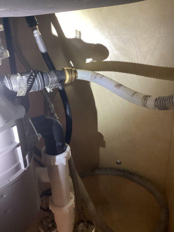 Responded to kitchen sink backup causing water to flow into dishwasher and create leak conditions. Upon arrival, accessed under-sink plumbing in cabinet area of 1951-era home. Inspected drain lines, P-trap assembly, and dishwasher drain connection for blockages and improper drainage. Cleared obstruction from drain system and verified proper water flow from sink. Tested dishwasher drain hose connection and confirmed no further backup occurring. System restored to normal operation with proper drainage established.