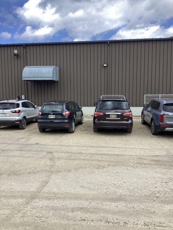 Responded to water intrusion issue at industrial property caused by cracked underground drain pipe collecting roof water. Inspected exterior building perimeter where corrugated metal wall meets cinder block foundation, identifying compromised drainage system with vertical pipe extending through gravel bed. Documented existing conditions of drain pipe infrastructure and surrounding area to assess extent of damage and determine appropriate repair strategy for the failing underground drainage system.