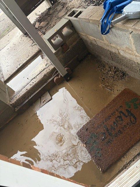 Responded to drainage issue at front entry where clogged floor drain was causing significant water pooling and standing water on concrete porch and steps during rainfall. Deployed jetter equipment to clear the obstruction in the drain line located at the entrance area. Successfully restored proper drainage function, eliminating water accumulation at the doorway and preventing further water damage to the concrete surfaces and foundation area.