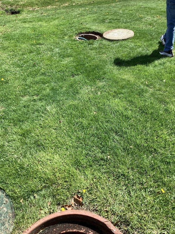 Responded to clogged drain issue in 1954-built home with blockage located under basement floor. Accessed main drain cleanout via exterior yard access point, removed concrete lid, and cleared obstruction using appropriate drain cleaning equipment. Verified proper flow restoration through main line, secured cleanout cover, and restored work area to original condition.