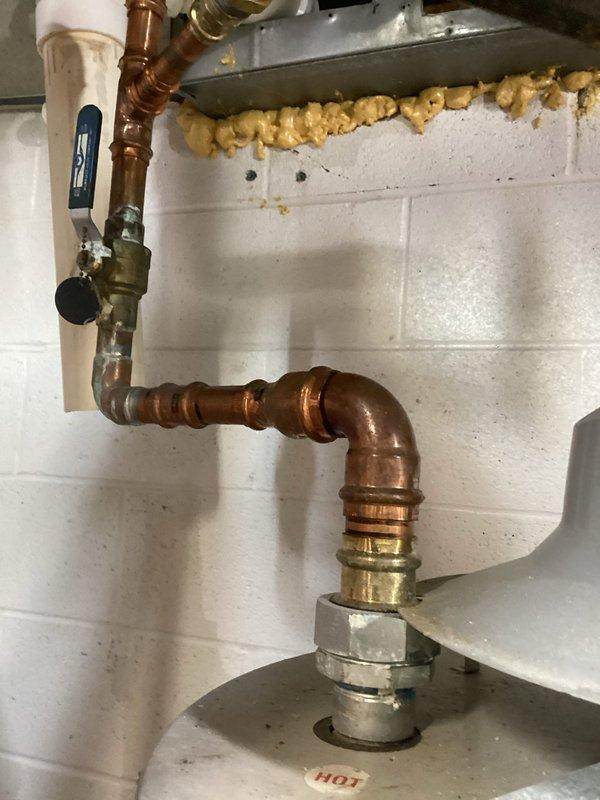 Conducted on-site assessment of existing electric water heater for tear-out and replacement estimate. Evaluated current installation including copper supply piping, pressure relief valve connections, electrical conduit and junction box configuration, and existing plumbing connections. Documented water heater specifications, mounting location against concrete block wall, and all associated piping and electrical components to provide accurate replacement proposal. Photographed existing unit markings, control assembly, safety labels, and all connection points to ensure proper sizing and installation planning for new water heater system.