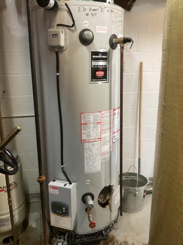 Conducted on-site assessment of existing electric water heater for tear-out and replacement estimate. Evaluated current installation including copper supply piping, pressure relief valve connections, electrical conduit and junction box configuration, and existing plumbing connections. Documented water heater specifications, mounting location against concrete block wall, and all associated piping and electrical components to provide accurate replacement proposal. Photographed existing unit markings, control assembly, safety labels, and all connection points to ensure proper sizing and installation planning for new water heater system.